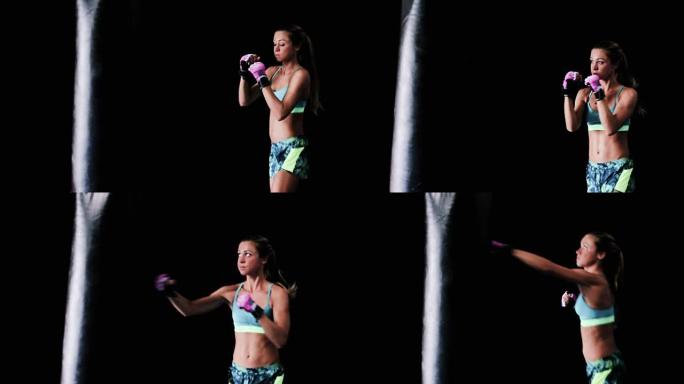 美丽的年轻女运动员锻炼自我防卫与拳击手套和身体袋。Instagram过滤器。