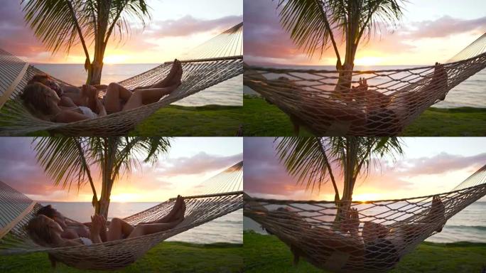 日落时在热带吊床上放松的浪漫情侣。夏季豪华假期。