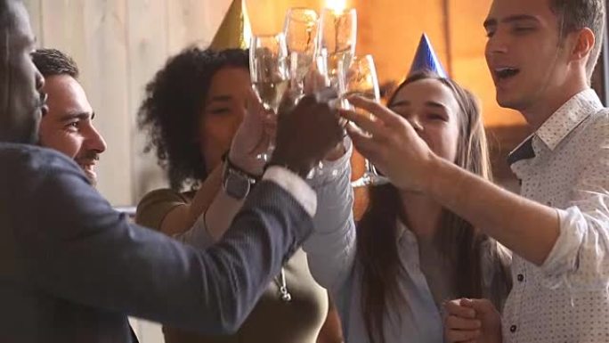 多样化的年轻派对人士庆祝碰杯，一起玩乐