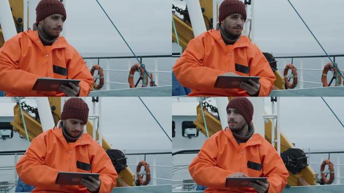 在船上旅行时，穿着休闲的渔夫使用带有导航地图的平板电脑。
