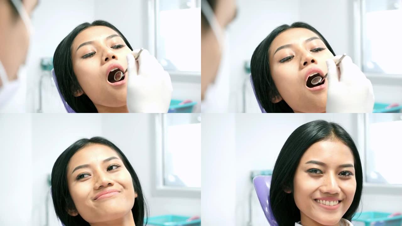 病人的肖像给牙医进行检查和牙齿清洁。牙医用镜子检查一位年轻女子的牙齿。