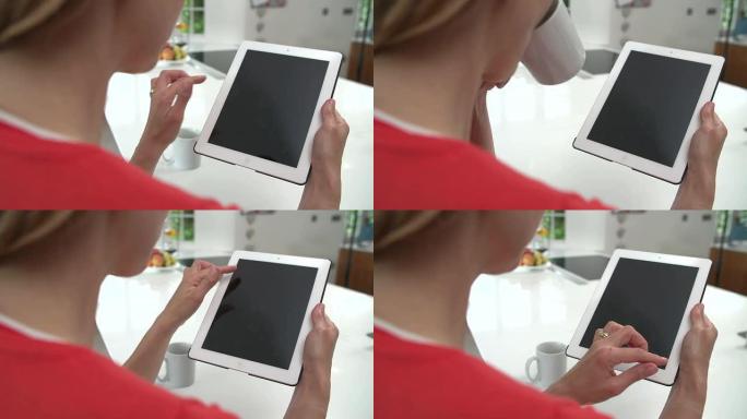 女人在厨房里在家使用数字平板电脑