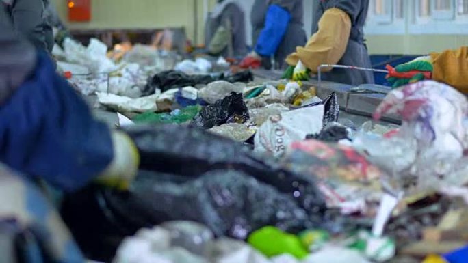 废物回收厂。工人们用手将垃圾分类回收。