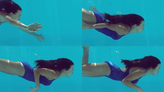 穿着蓝色泳衣的黑发女人在水下游泳