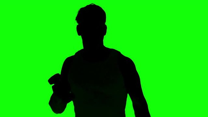 一名男子在绿色屏幕上举起哑铃的剪影