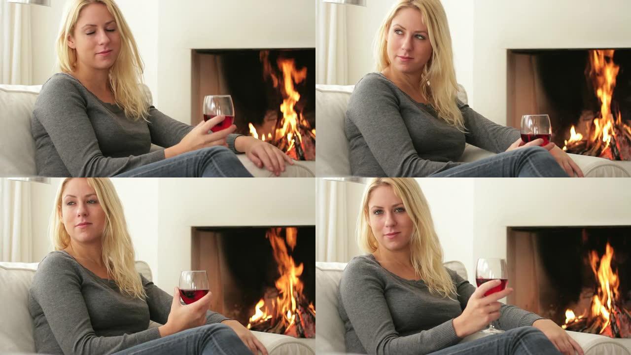 女性在壁炉前喝酒温暖漂亮女性休闲喝酒