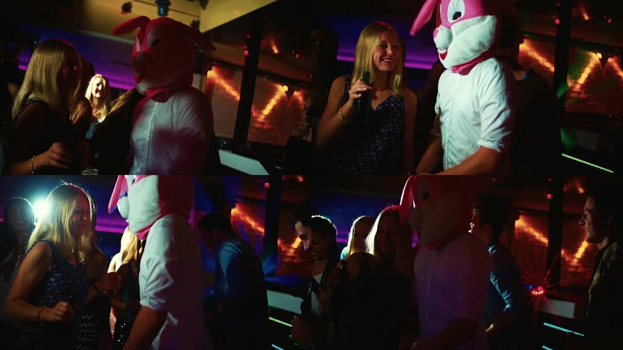 盖伊在派对俱乐部扮演兔子下一个年轻女子跳舞