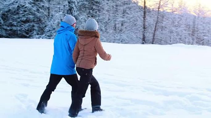 夫妇在白雪皑皑的森林里散步