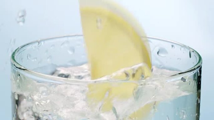 冰块和柠檬片掉在水杯中