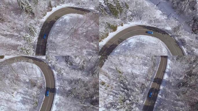 空中: 蓝色汽车在神奇的白雪皑皑的冬季仙境中行驶急转弯