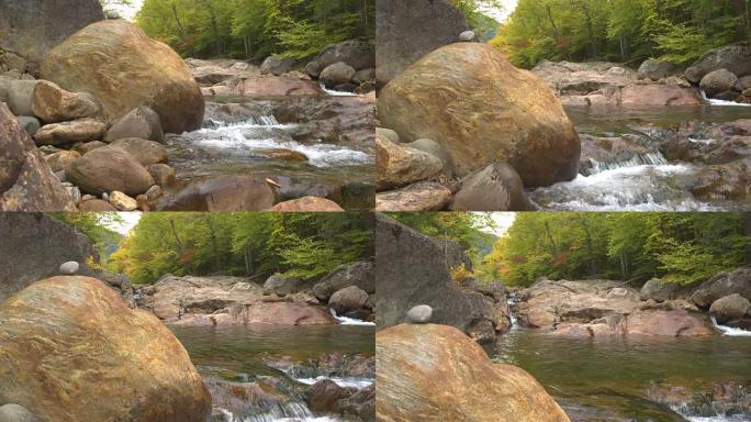 特写: 山溪在秋天的森林中从岩石上汇入河池