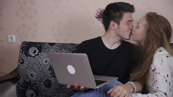 年轻夫妇在室内共享笔记本电脑