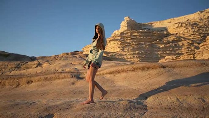 年轻女子在岩石海岸线上摆姿势。晴天