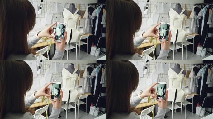 年轻的女性服装设计博客作者正在拍摄剪裁假人，上面固定着半成品服装。女孩的手和智能手机的特写镜头。