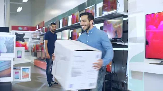 电子商店的年轻人购买了大型无人机，并与盒子快乐地跳舞。明亮而现代的商店拥有所有最新的设备。