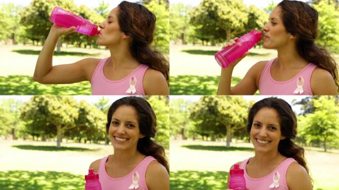 快乐女人穿粉红色为乳腺癌意识饮水