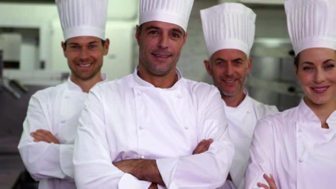 四个快乐的厨师双臂交叉看着相机
