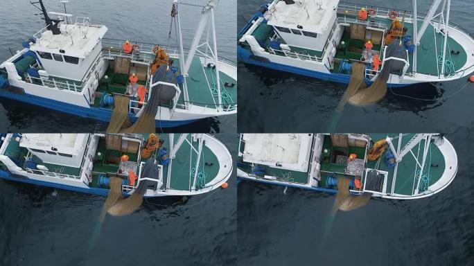 在海上用拖网捕鱼的商船的航拍。