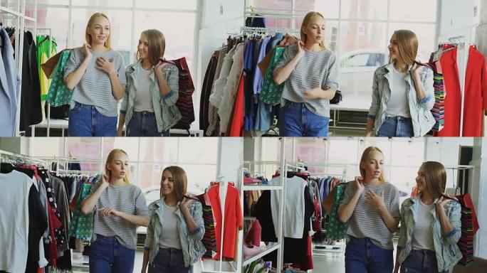 多莉拍摄的两个女孩拿着五颜六色的纸袋慢慢走过宽敞的商店。其中一个在感情上说话，另一个在倾听和微笑。
