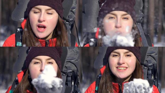 快乐的年轻女孩从手掌吹雪。