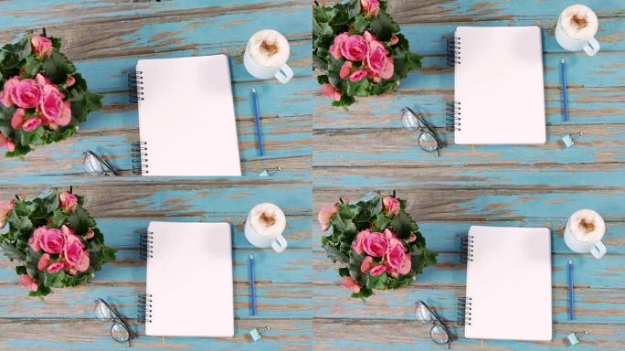 粉红色的花朵，一杯咖啡，日记，活页夹和眼镜