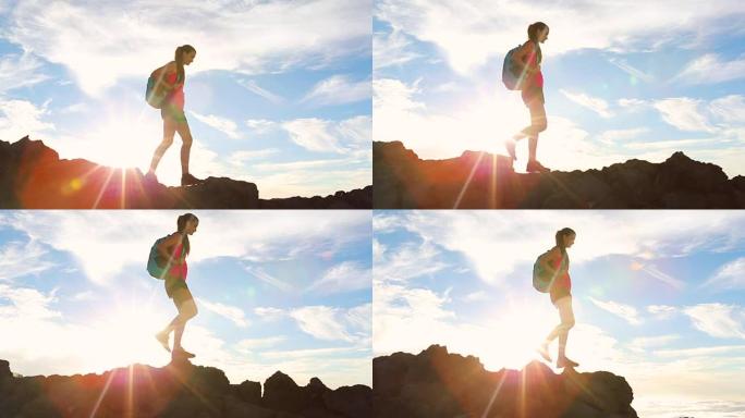 背包徒步旅行者带着太阳耀斑在山顶徒步旅行。年轻健康的女人在大自然中的冒险。