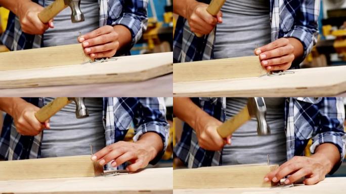 专注于木匠在木板上锤击