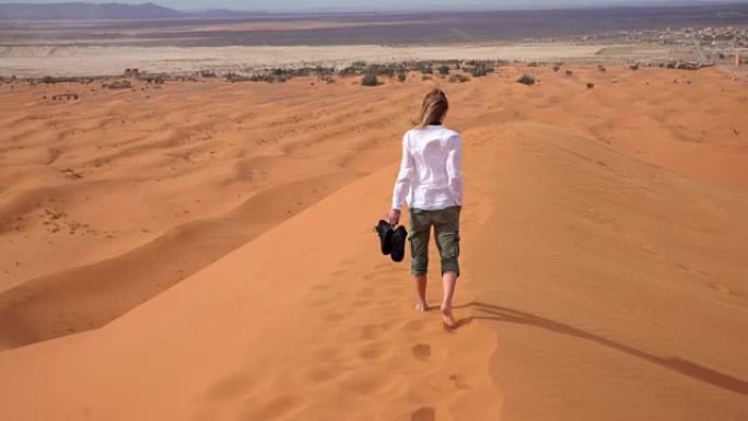 女人赤脚穿过沙漠