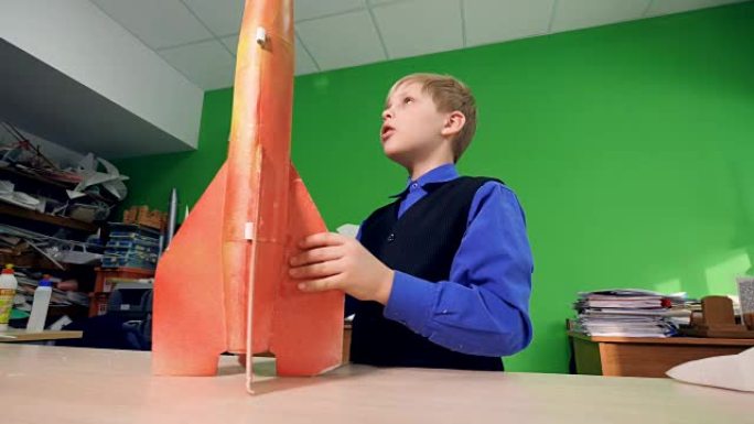 男孩看着火箭模型。4K。