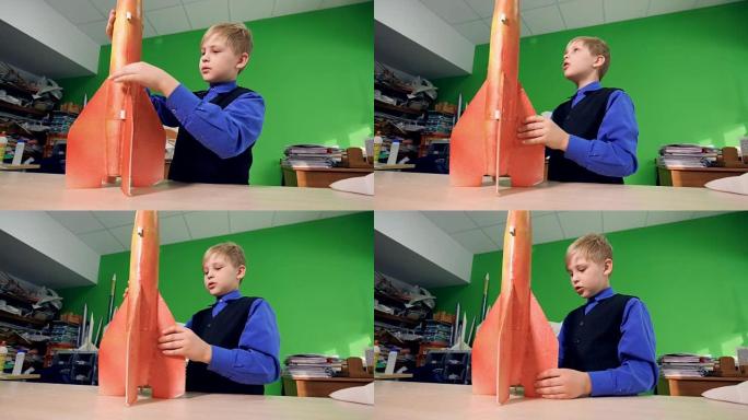 男孩看着火箭模型。4K。