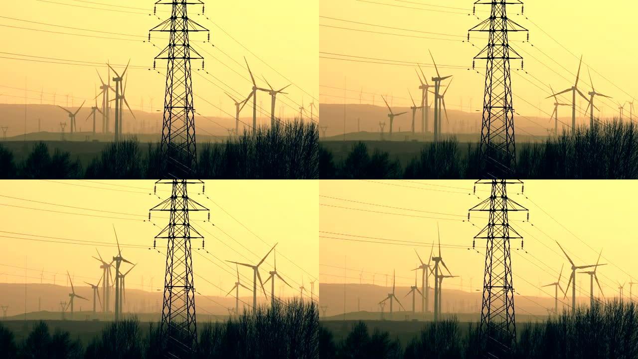 日落时带电塔的风力发电站涡轮机