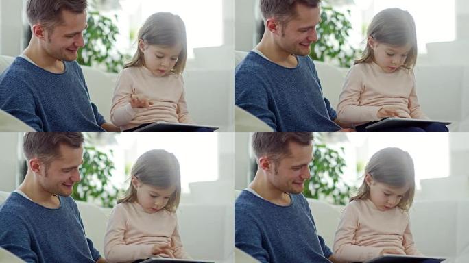 父亲看着女儿玩平板电脑