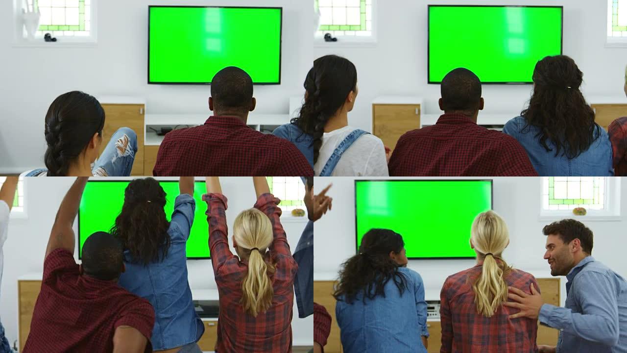 一群年轻朋友在电视上观看体育节目并欢呼