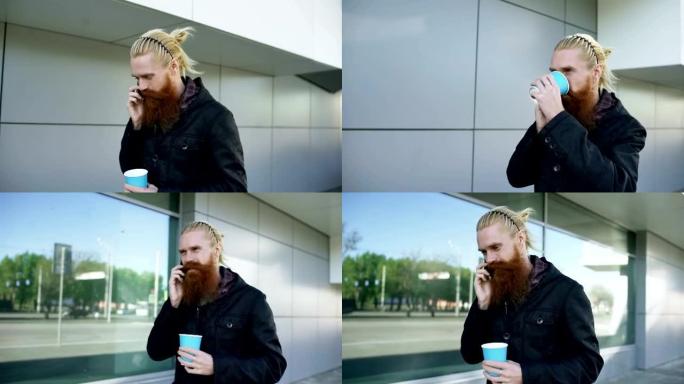 多莉拍摄了快乐胡子的年轻人在街上散步时在智能手机上聊天和喝咖啡的照片