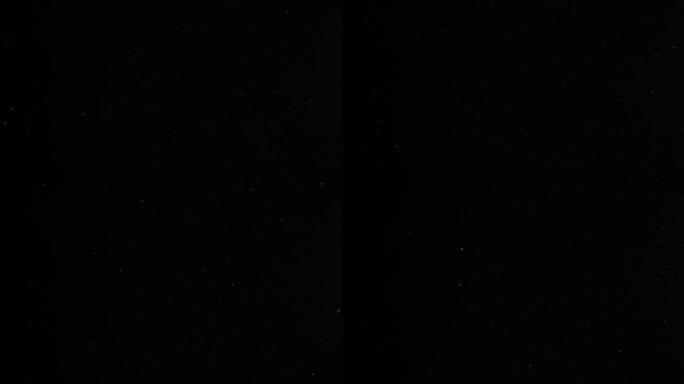 散焦的散景粒子慢慢落在黑色背景上的光线中。变形的真实镜头光斑，易于在混合/叠加模式下使用。