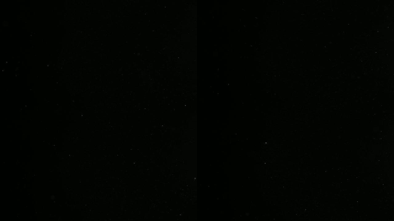 散焦的散景粒子慢慢落在黑色背景上的光线中。变形的真实镜头光斑，易于在混合/叠加模式下使用。