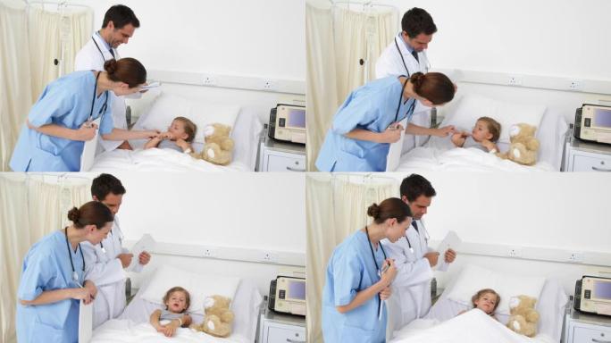生病的女孩躺在床上与护士和医生交谈