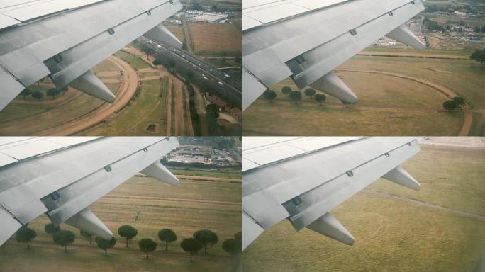 从飞机窗口到飞机机翼的视图。飞机降落在意大利的机场到跑道