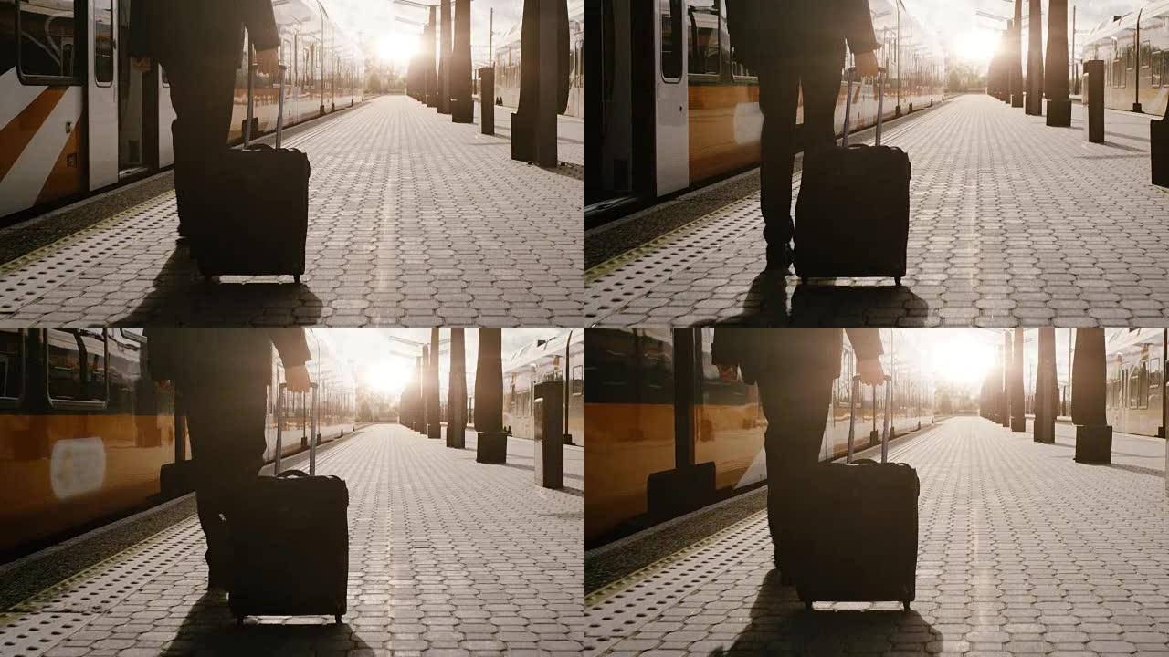 自信的男人带着行李在日落时间在火车站行走