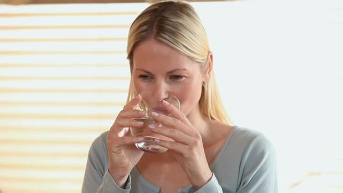 女人从桌子上提了一杯水