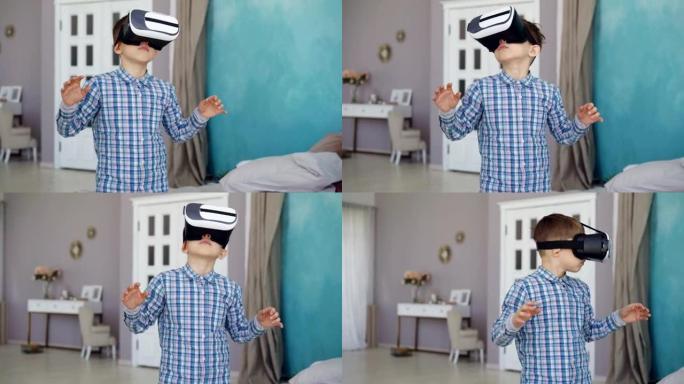 可爱的小男孩正在尝试虚拟现实眼镜，站在他的公寓里打手势。现代科技、娱乐和人的概念。