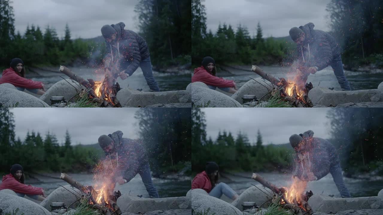 年轻夫妇在炉火旁放松。广阔的景观