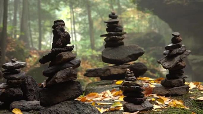 特写: 在华丽的雾蒙蒙的秋天森林中，一堆堆积在苔藓岩石上的石头