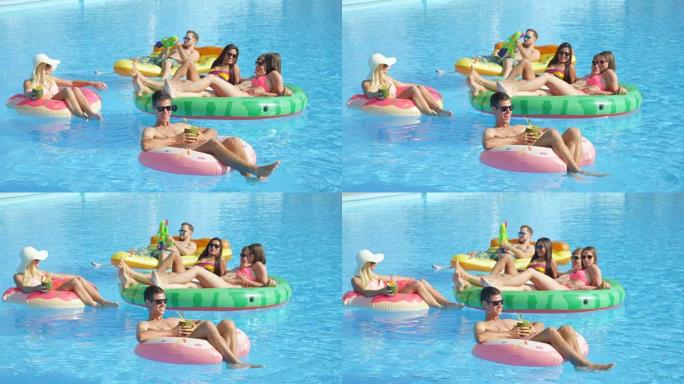 慢动作: 快乐的年轻朋友在充气漂浮物上享受暑假