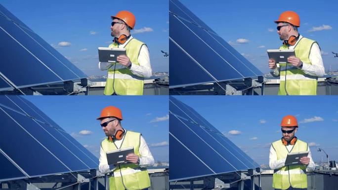 一名工人检查屋顶上的面板。工程师检查太阳板的质量。