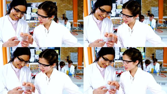 微笑的女学生在实验室的一块玻璃上做实验