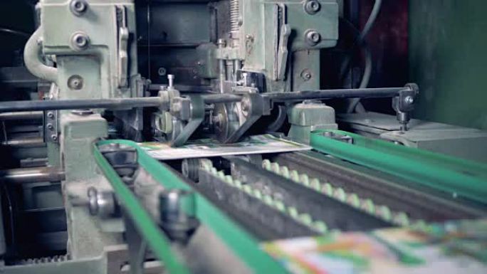 一台工业机器正在切断印刷杂志的边缘