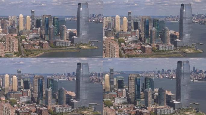 空中: 在新泽西州市区的摩天大楼周围飞行，俯瞰着纽约曼哈顿