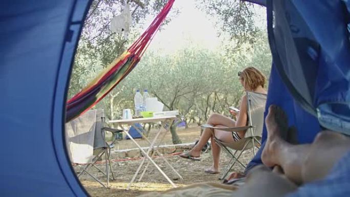 个人视角情侣在露营地的帐篷里放松