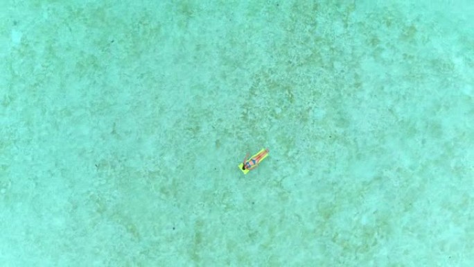 4k天线: 在美丽的夏日，穿着比基尼的女人躺在充气气床筏上，漂浮在美丽的热带岛礁上，漂浮在广阔的太平